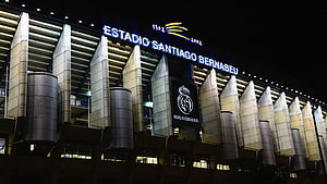 Santiago Bernabeu Stadium Exterior at Night with Real Madrid Crest and Illuminated Facade HD wallpaper