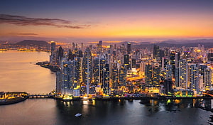Panama City skyline at sunset with illuminated skyscrapers and waterfront reflections HD wallpaper