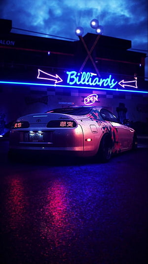 Toyota Supra MK4 parked under a glowing neon billiards sign in a rainy cyberpunk city street HD phone wallpaper