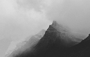 Moody Black and White Mountain Peak Emerging Through Thick Fog and Clouds HD wallpaper