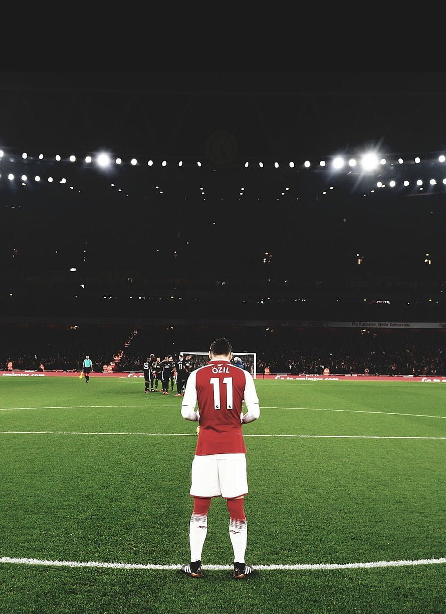 Mesut Özil in Arsenal Kit Standing on the Pitch at Night Under Stadium Lights HD phone wallpaper