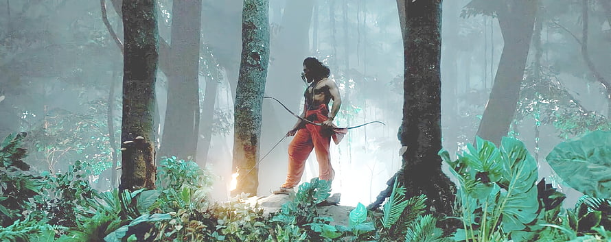 Ram Charan as Alluri Sitarama Raju in RRR cinematic jungle scene with bow and arrow HD wallpaper