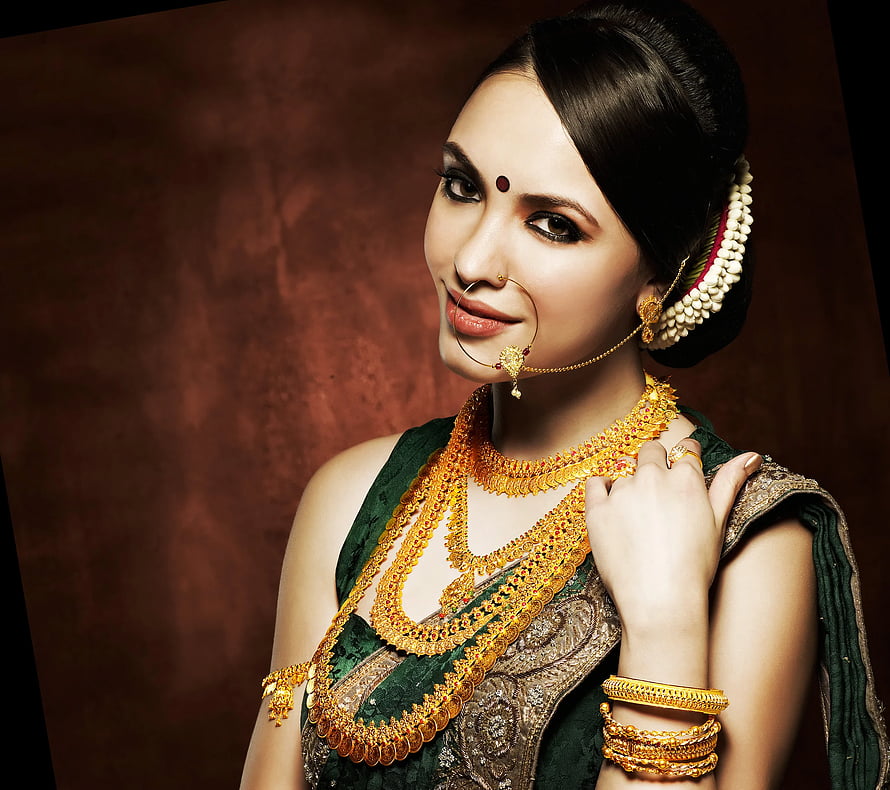Elegant Indian Woman in Traditional Green Saree with Gold Jewelry and Floral Hairpiece HD wallpaper