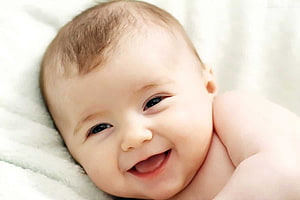 Smiling Baby Boy Lying on Soft White Blanket Close-Up Portrait HD wallpaper