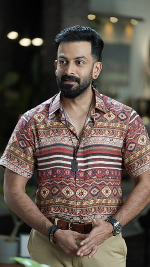 Prithviraj Sukumaran in a patterned short-sleeve shirt with a full beard and wristwatch HD phone wallpaper