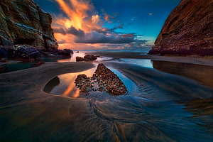 Dramatic Coastal Sunset with Rocky Cliffs and Reflective Tidal Pools HD wallpaper