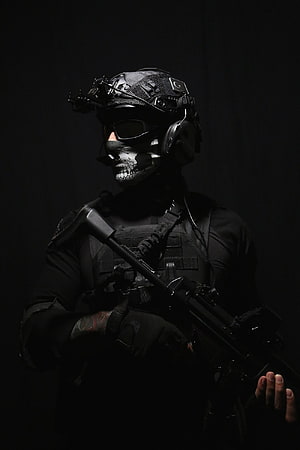 Tactical Operator in Black Gear with Skull Face Paint and Assault Rifle HD phone wallpaper