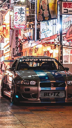 Brian O'Conner's Nissan Skyline GT-R R34 in a Neon-Lit Tokyo Street Scene HD phone wallpaper