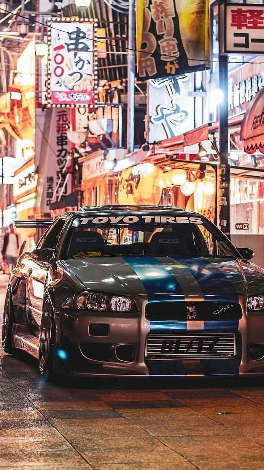 Brian O'Conner's Nissan Skyline GT-R R34 in a Neon-Lit Tokyo Street Scene HD phone wallpaper