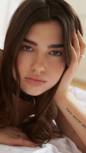 Dua Lipa Close-Up Portrait with Hand on Face and Wrist Tattoo HD phone wallpaper