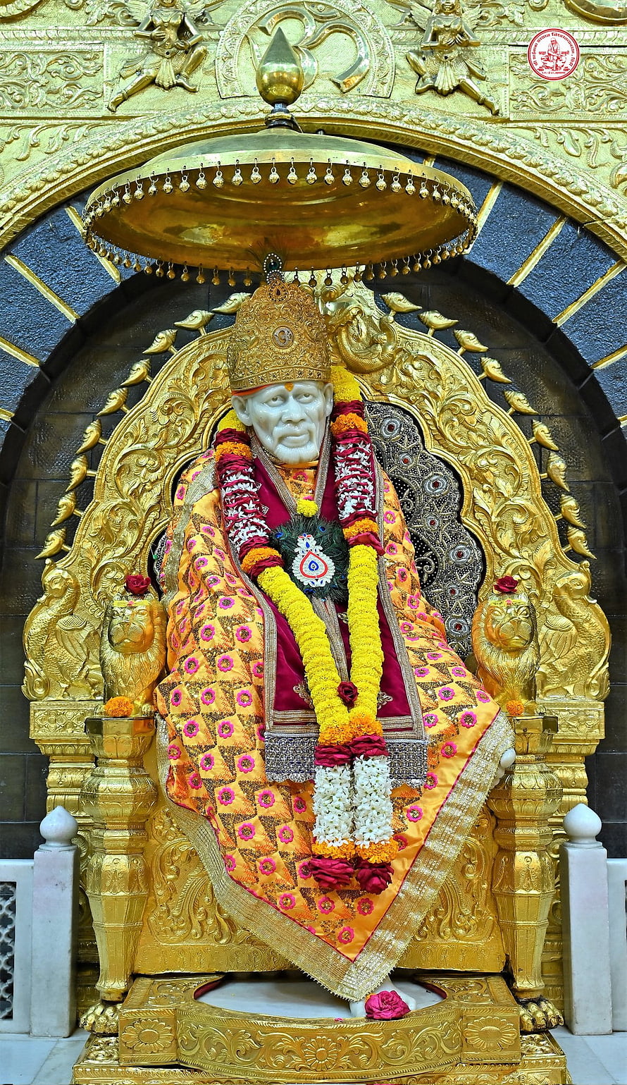 Sai Baba Temple Idol Adorned in Golden Garments and Marigold Garlands HD phone wallpaper