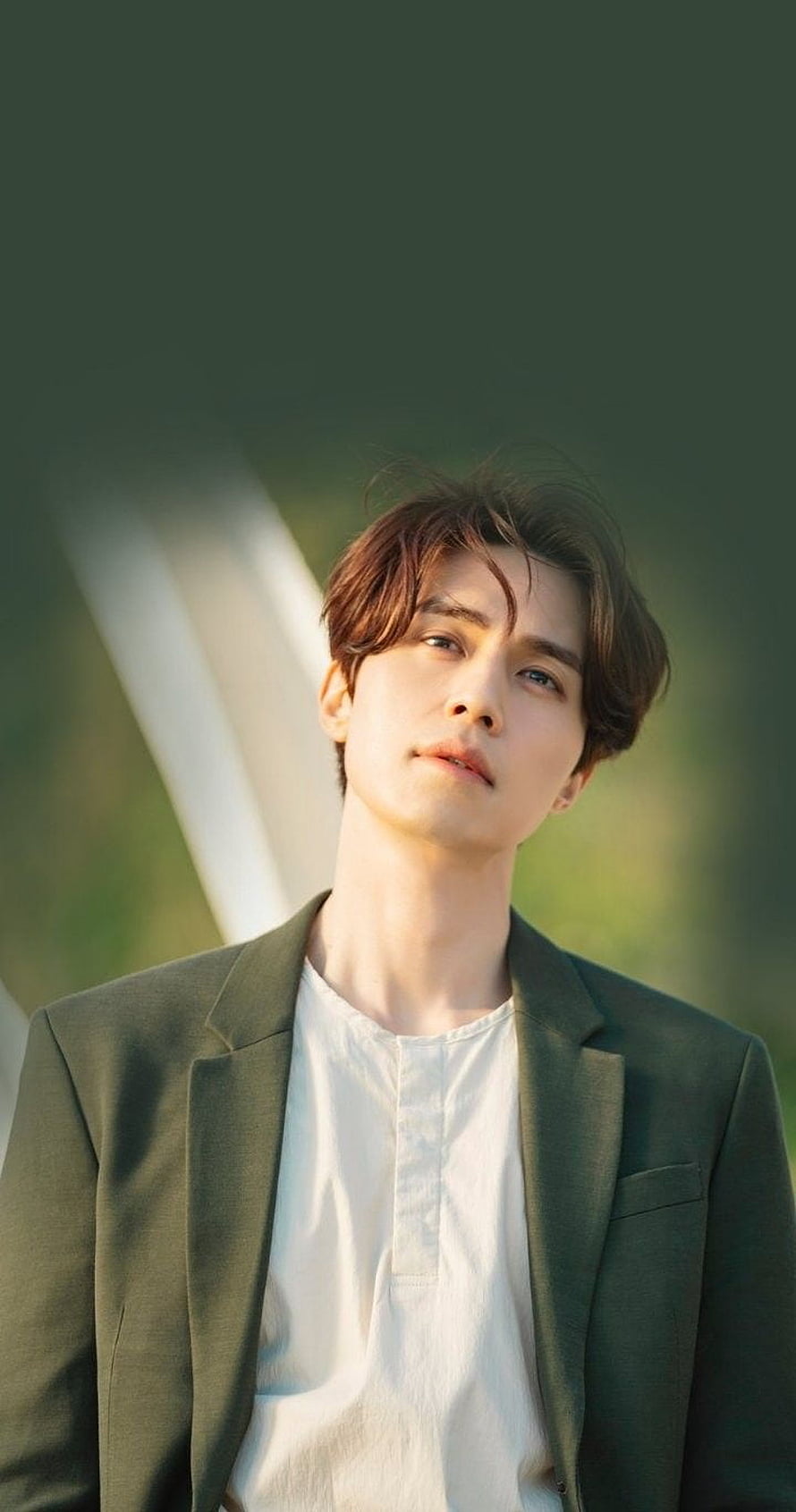 Lee Dong Wook in olive blazer and white shirt with soft natural light and blurred green background HD phone wallpaper