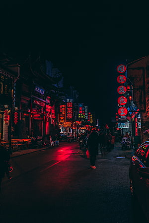 Neon-lit Chinese street at night with glowing red signboards and pedestrians walking through a dark urban alleyway HD phone wallpaper