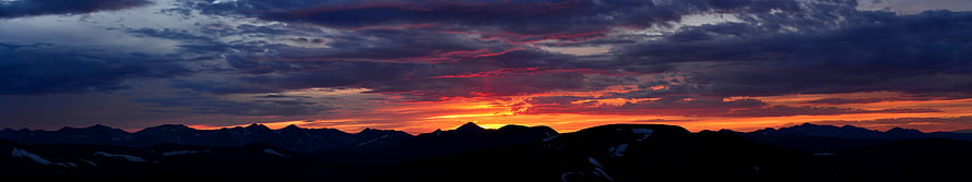 Dramatic Mountain Sunset Panorama with Fiery Orange Sky and Dark Silhouetted Peaks HD wallpaper