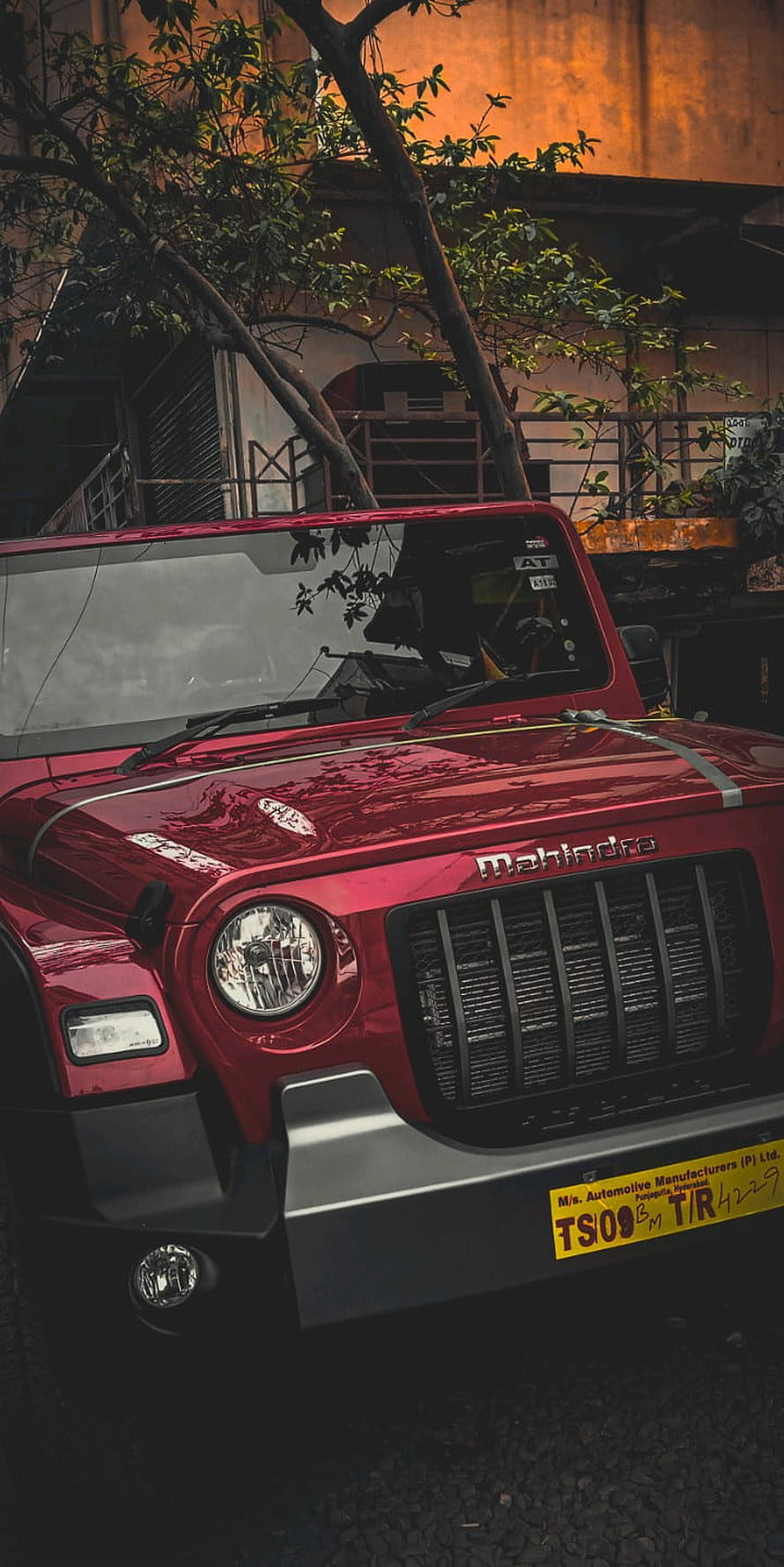 Red Mahindra Thar Front Grille and Headlight Close-Up in Urban Setting HD phone wallpaper