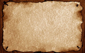 Aged Parchment Scroll with Burnt Edges on Rustic Wooden Surface HD wallpaper
