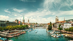 Zurich Old Town Skyline with Limmat River, Historic Church Spires, and Moored Boats Under a Blue Sky HD wallpaper