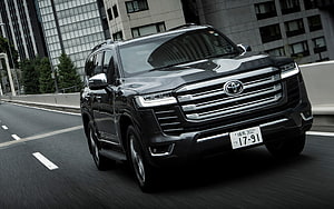Black Toyota Land Cruiser 300 Series SUV Driving on Urban Highway HD wallpaper