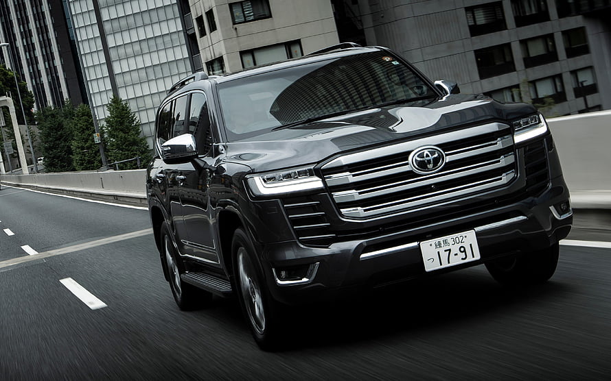 Black Toyota Land Cruiser 300 Series SUV Driving on Urban Highway HD wallpaper