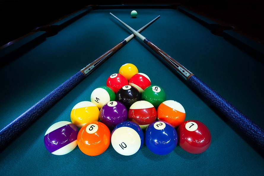Rack of Billiard Balls and Crossed Cues on a Green Felt Pool Table HD wallpaper