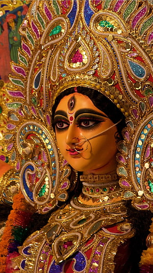 Ornate Durga Maa Brahmacharini idol adorned in gold jewelry and vibrant traditional temple attire HD phone wallpaper
