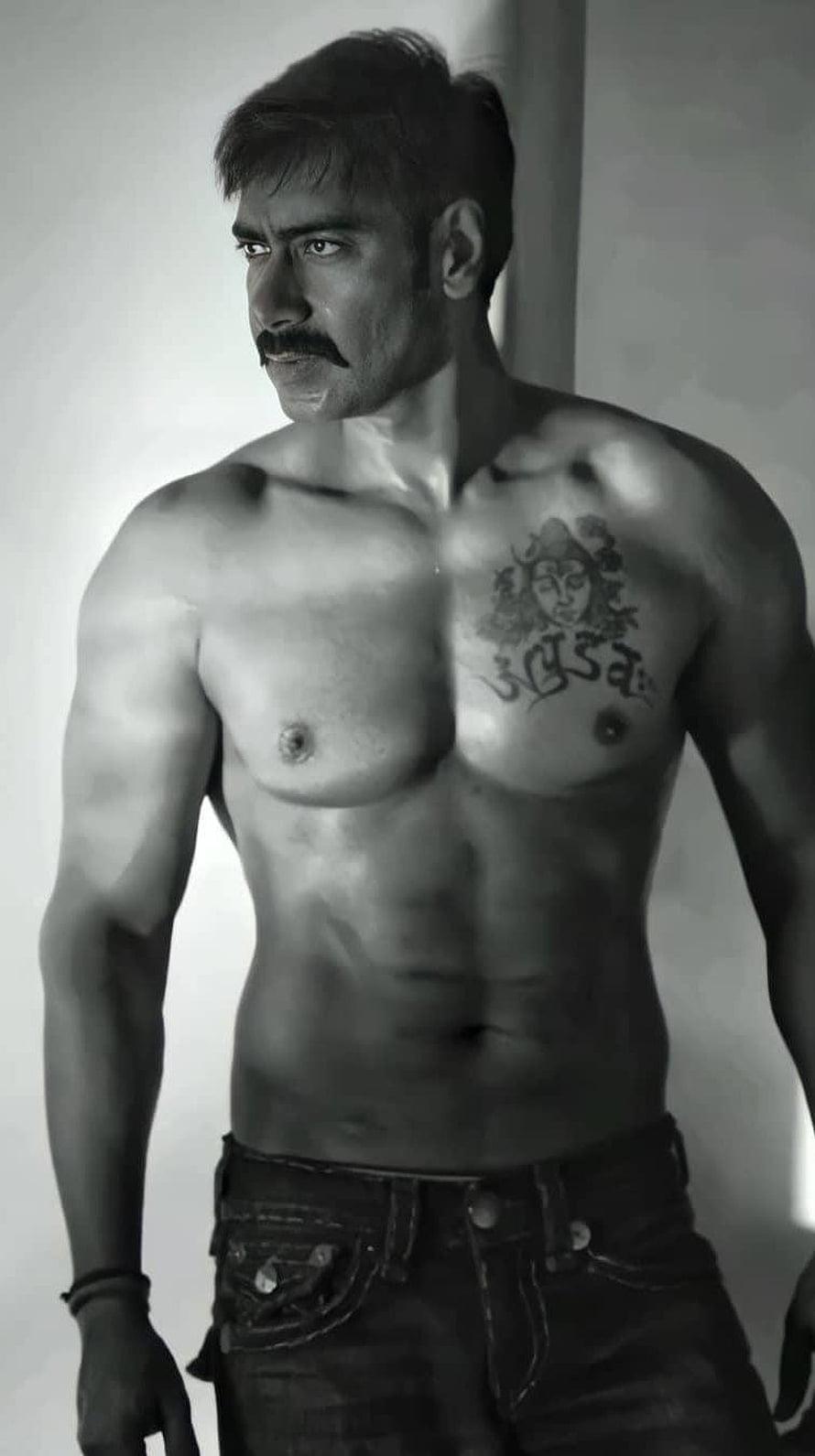 Ajay Devgan Black and White Portrait with Chest Tattoo and Intense Gaze HD phone wallpaper