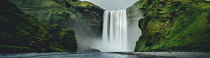 Mossy Green Waterfall Cascading Into Misty Pool Between Rocky Cliffs HD wallpaper