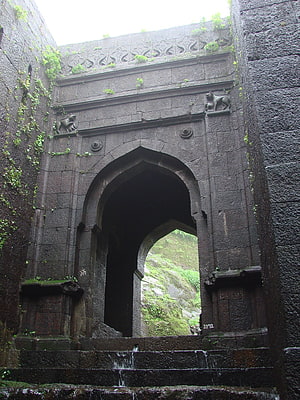 Ancient Stone Archway at Raigad Fort with Mossy Walls and Carved Details HD phone wallpaper
