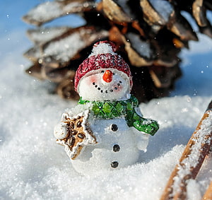 Charming Ceramic Snowman Figurine Holding Gingerbread Cookie in Snowy Winter Scene HD wallpaper