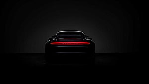 Porsche 911 Turbo S Rear Silhouette with Glowing Red Light Bar in Dark Studio Setting HD wallpaper