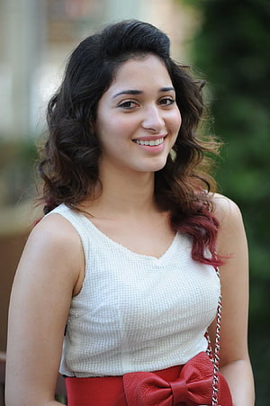 Tamanna Bhatia smiling portrait in white top and red bow belt HD phone wallpaper