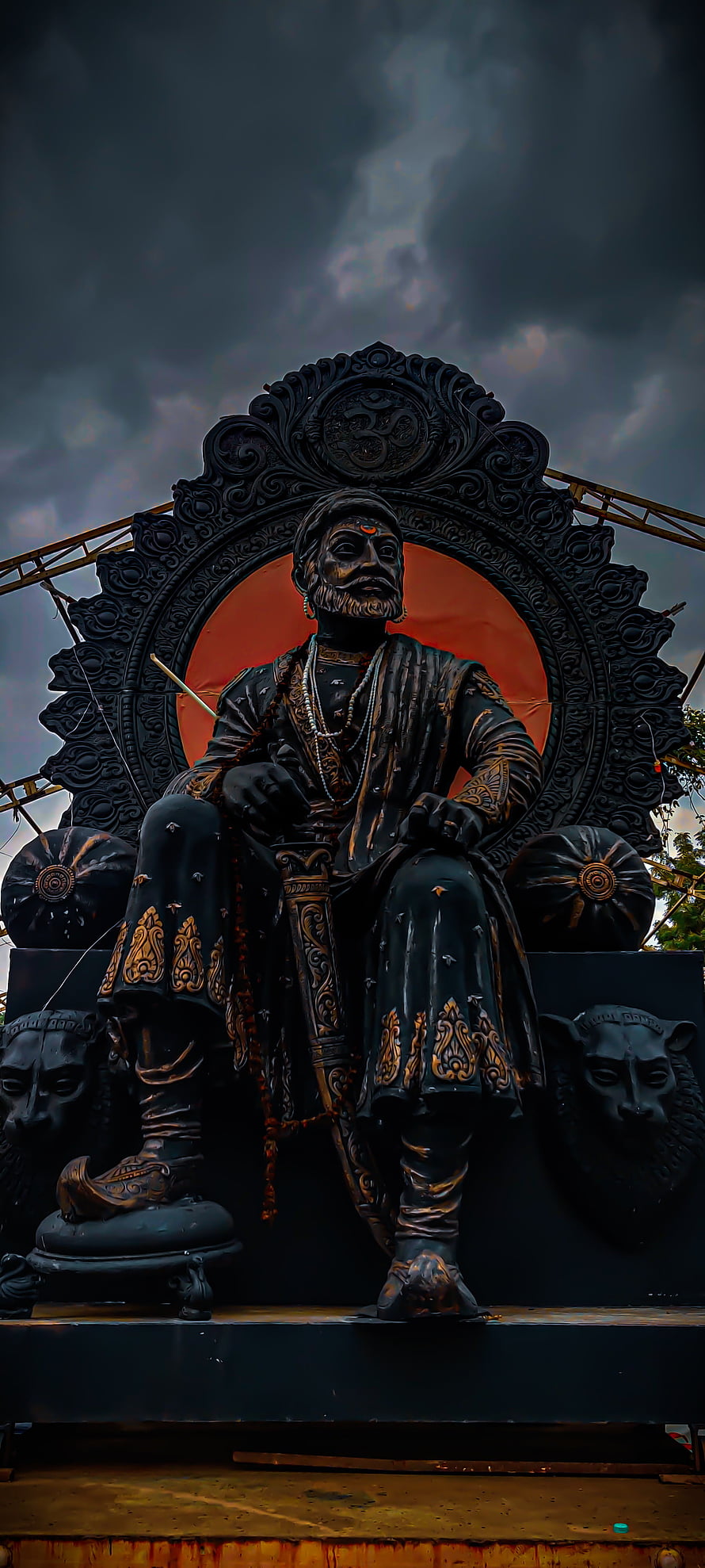Shivaji Maharaj Statue Seated on Ornate Throne Under Dramatic Stormy Sky HD phone wallpaper