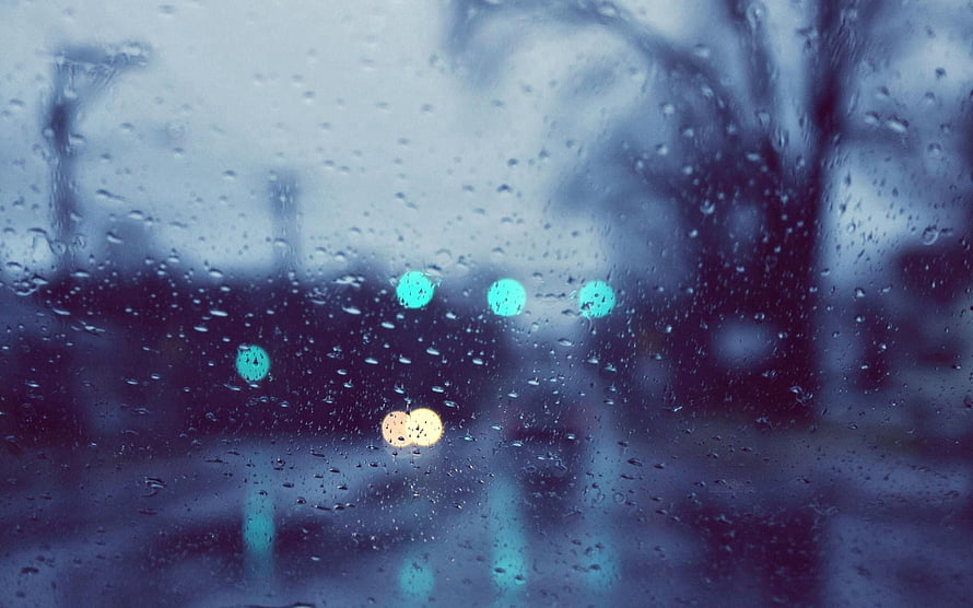 Raindrops on a glass window with blurred city lights and bokeh in a cool blue tone HD wallpaper