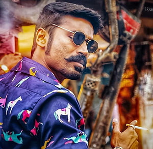 Dhanush in Maari wearing round sunglasses and a colorful horse-patterned shirt HD wallpaper