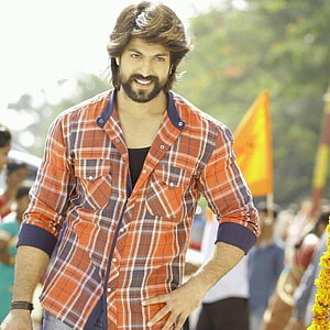 Yash in Orange Plaid Shirt at Outdoor Festival with Marigold Decorations HD phone wallpaper