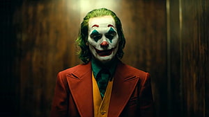 Joaquin Phoenix as the Joker in a red suit with clown makeup and green hair HD wallpaper