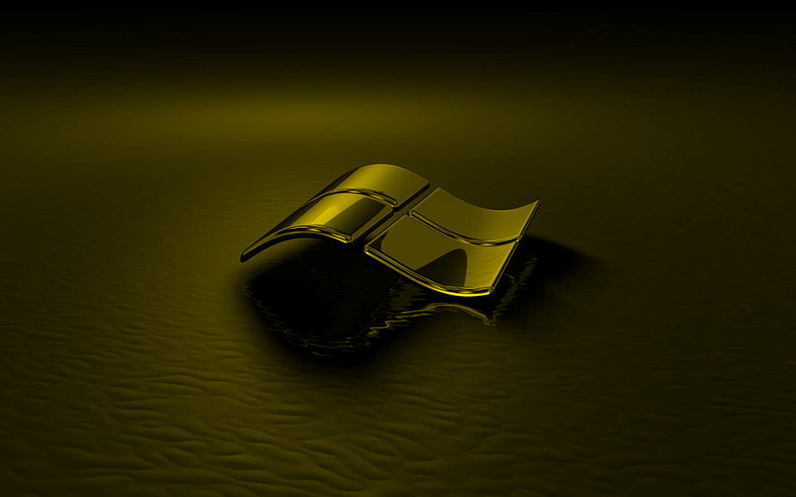 Glossy Gold Windows Emblem Resting on Dark Textured Surface with Dramatic Lighting HD wallpaper