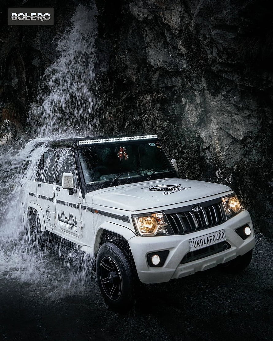 White Mahindra Bolero SUV Driving Through Waterfall Spray in Rocky Terrain HD phone wallpaper