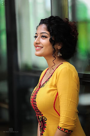 Anjali Nair in a yellow embroidered kurta with traditional jewelry and curly hair HD phone wallpaper