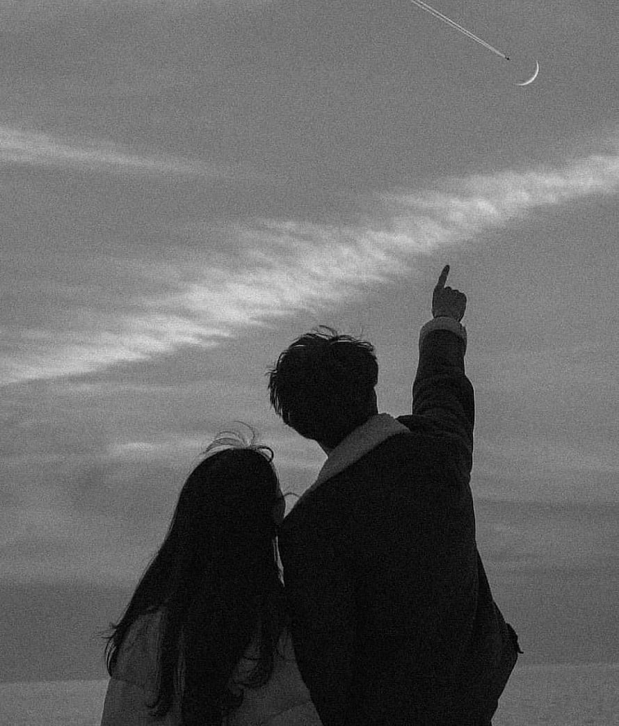 Black and white silhouette of a couple pointing at a crescent moon in a cloudy sky HD phone wallpaper