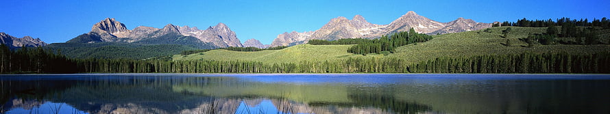 Panoramic Mountain Lake Reflection with Forested Hills and Clear Blue Sky HD wallpaper