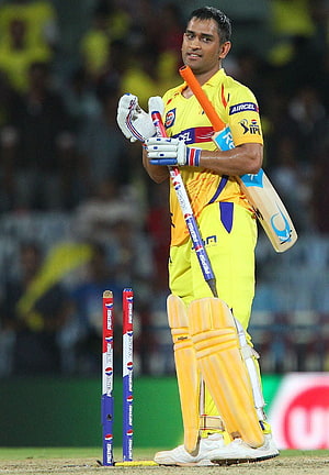 MS Dhoni in Chennai Super Kings yellow kit holding cricket bat and stumps on the field HD phone wallpaper