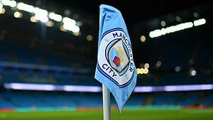 Manchester City Corner Flag at Etihad Stadium Under Nighttime Floodlights HD wallpaper