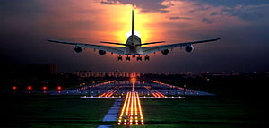 Large Commercial Airplane Landing on Runway at Sunset with Illuminated Approach Lights HD wallpaper