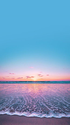 Pastel Ocean Sunset with Pink Horizon and Gentle Waves on a Sandy Beach HD phone wallpaper