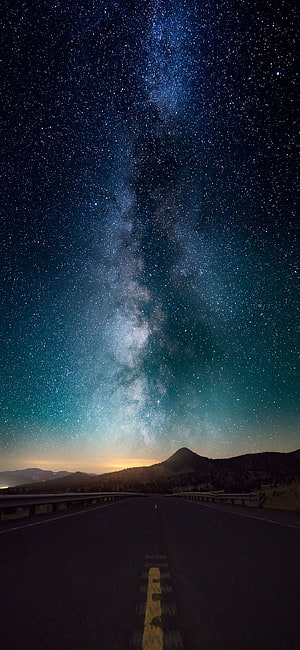 Milky Way Galaxy Arching Over a Desert Highway at Night with Distant Mountains HD phone wallpaper