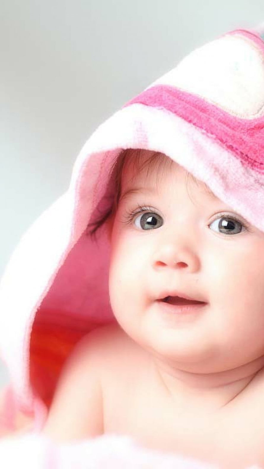 Adorable Baby Girl Wearing a Soft Pink Hooded Towel with Wide Eyes HD phone wallpaper