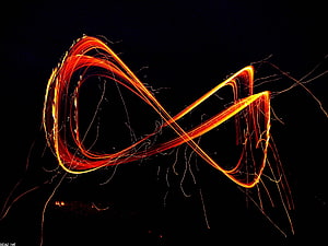 Vibrant Orange Infinity Symbol Created with Long Exposure Light Painting on Black Background HD wallpaper