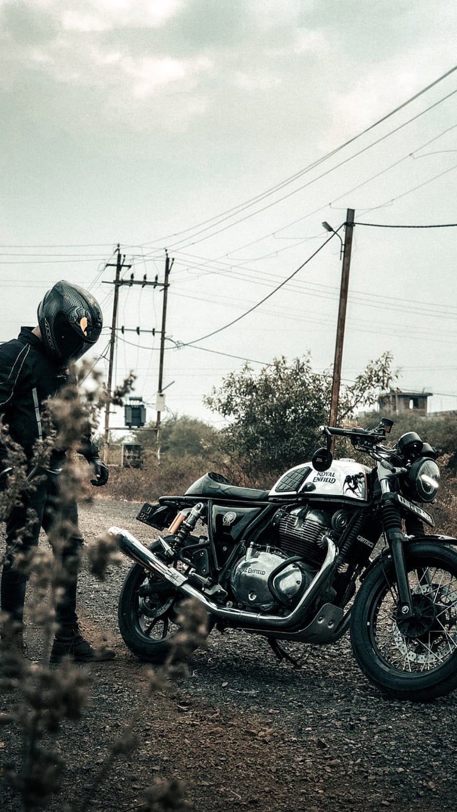 Royal Enfield Continental GT 650 parked on a gravel road with a rider in full gear HD phone wallpaper