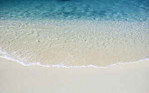 Aerial View of Turquoise Ocean Waves Lapping Against White Sand Beach HD wallpaper
